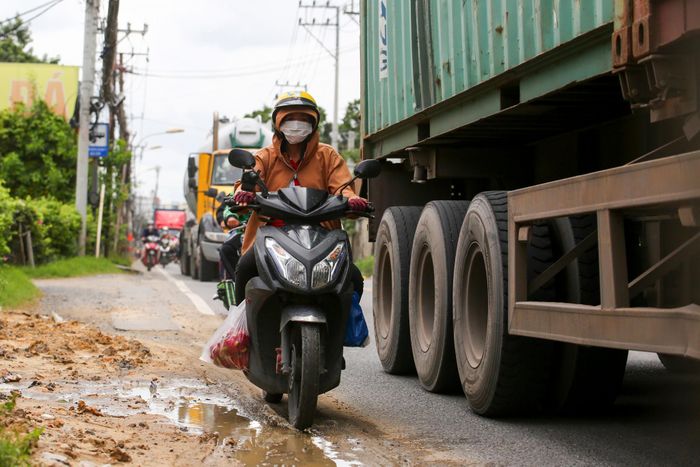  Không gian lưu thông chật hẹp khiến người đi xe máy phải di chuyển sát sườn xe container khi qua tuyến đường này. 