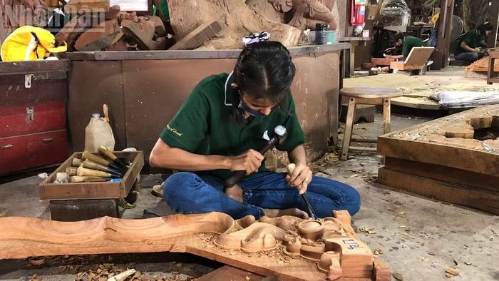 Thợ mộc tỉ mỉ chạm khắc từng chi tiết gỗ tại xưởng chế tác. (Ảnh: MINH THẮNG)