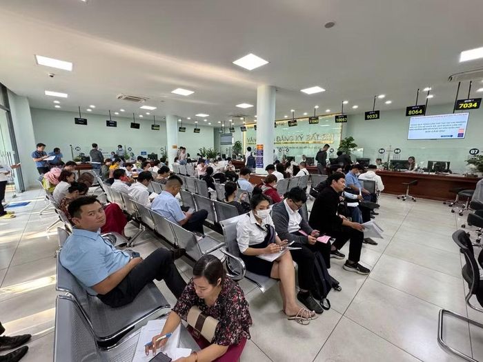 Người dân thực hiện thủ tục hành chính tại Văn phòng Đăng ký đất đai. (Ảnh: QUANG QUÝ)