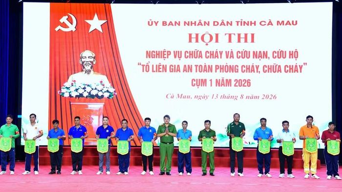 Đại tá Trần Thanh Xuân, Trưởng Phòng Cảnh sát Phòng cháy chữa cháy và cứu nạn cứu hộ Công an tỉnh Cà Mau (đứng giữa) trao cờ lưu niệm cho các đội thi. (Ảnh: Hữu Đệ)