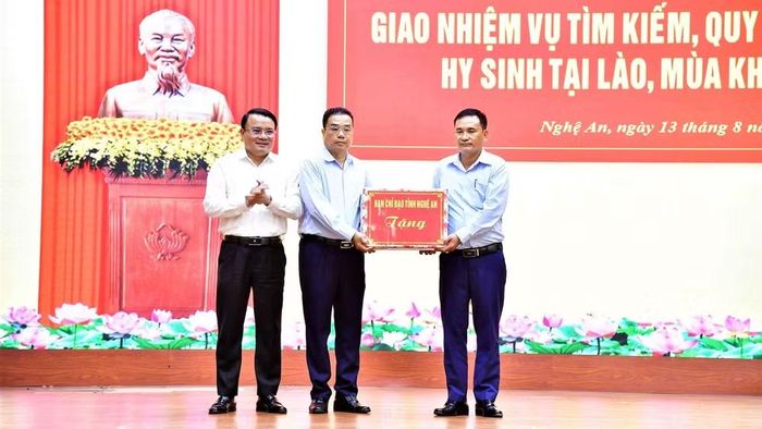 Ông Phùng Thành Vinh, Phó Chủ tịch Ủy ban nhân dân tỉnh, Trưởng Ban Chỉ đạo về tìm kiếm, quy tập và xác định danh tính hài cốt liệt sĩ tỉnh Nghệ An tặng quà động viên Đội Quy tập liệt sĩ trước khi lên đường làm nhiệm vụ. ̣(Ảnh: TIẾN DŨNG)