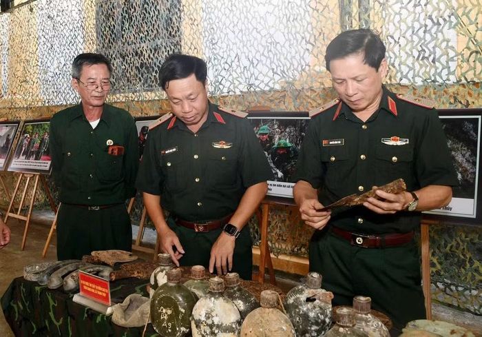 Các đại biểu xem những hiện vật tìm thấy trong quá trình tìm kiếm, quy tập hài cốt liệt sĩ. (Ảnh: THANH THỦY)