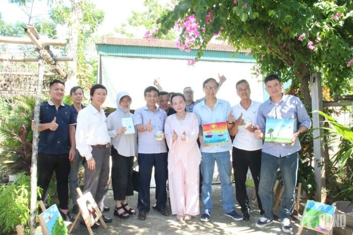 Các thành viên đoàn công tác chụp ảnh với nghệ nhân trà Việt Lê Thảo My, chủ mô hình đa dạng hóa cây chè Gay mang hiệu quả kinh tế cao cho người dân địa phương.