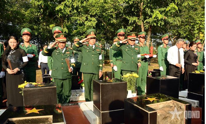 Các đại biểu thực hiện nghi thức đưa hài cốt liệt sĩ về an táng tại Nghĩa trang liệt sĩ Bình Phước.