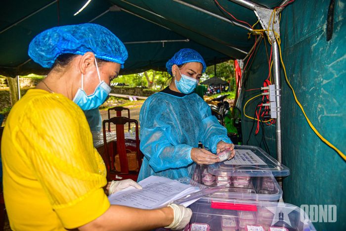 Nhân viên y tế tỉ mỉ lấy mẫu sinh phẩm hài cốt liệt sĩ phục vụ công tác xét nghiệm, xác định danh tính. 