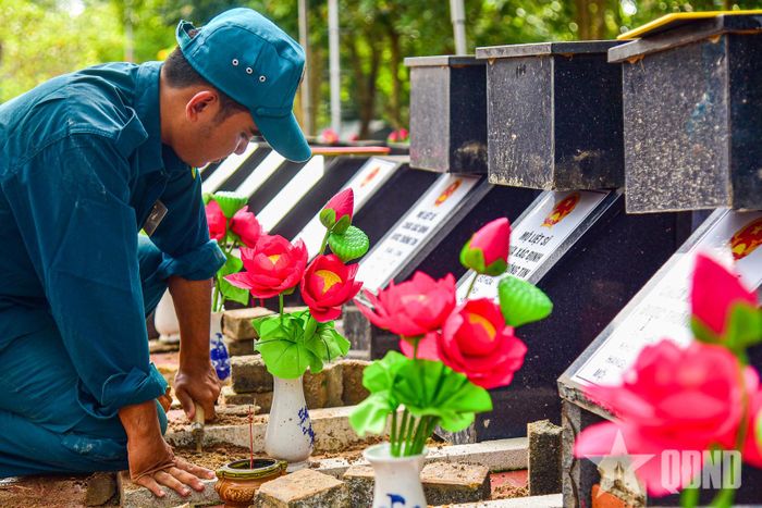  Chiến sĩ dân quân cẩn trọng thực hiện công việc khai quật phần mộ liệt sĩ.  