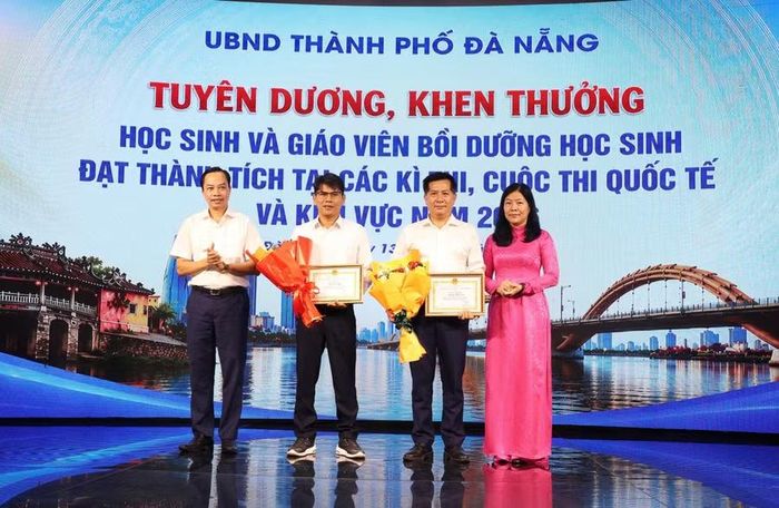 Ông Quảng Văn Ngọc (bìa trái), Trưởng ban Văn hóa - Xã hội HĐND thành phố và bà Lê Thị Bích Thuận, Giám đốc Sở GD&ĐT (bìa phải) khen thưởng giáo viên tham gia bồi dưỡng học sinh đạt thành tích cao.