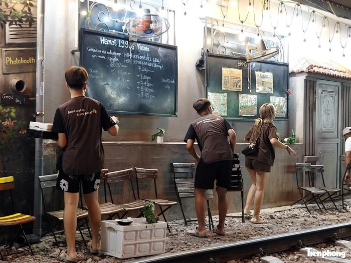 Nhân viên kê bàn ghế ra gần khu vực đường ray để khách ngồi.