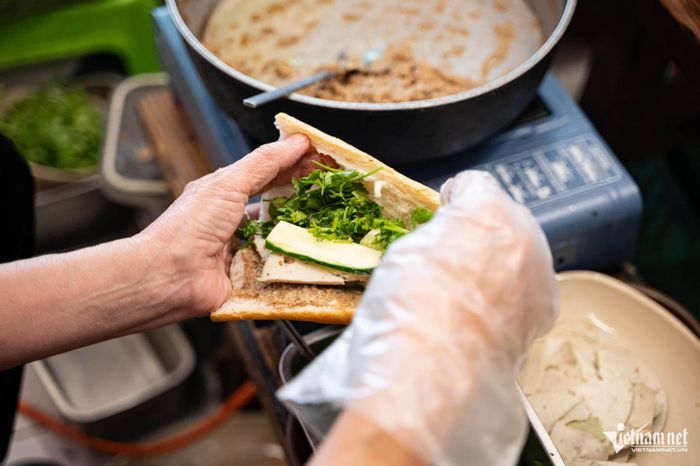 Nhiều khách nước ngoài thích thú trải nghiệm bánh mì pate chay của nhà hàng. Ảnh: Nguyễn Huy