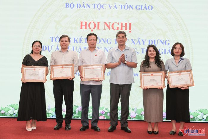 Thứ trưởng Y Vinh Tơr trao Bằng khen của Bộ trưởng Bộ Dân tộc và Tôn giáo tặng các cá nhân có thành tích xuất sắc trong công tác xây dựng Luật tín ngưỡng, tôn giáo (sửa đổi). Ảnh: Lê Anh Dũng