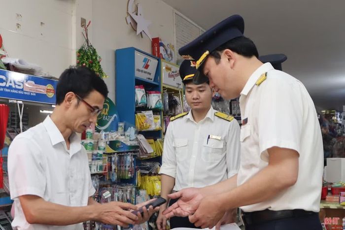 Cán bộ Thuế tỉnh Hà Tĩnh tuyên truyền các chính sách thuế mới tới hộ kinh doanh trên địa bàn.
