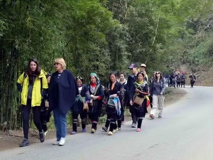 Khách du lịch nước ngoài trải nghiệm du lịch cộng đồng khi đến Sa Pa. (Ảnh: Thanh Hà/TTXVN)