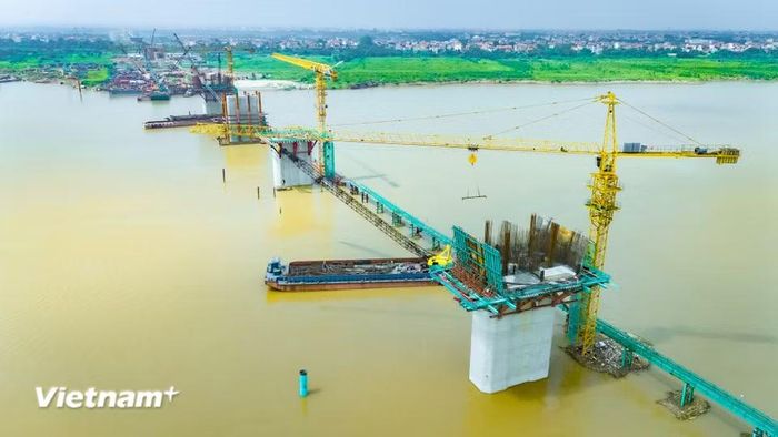 Ghi nhận thực tế tại khu vực thi công qua sông Hồng, diện mạo của cây cầu trọng điểm kết nối giữa huyện Mê Linh và huyện Đan Phượng (xã Ô Diên) đã dần hình thành. (Ảnh: Hoài Nam/Vietnam+)