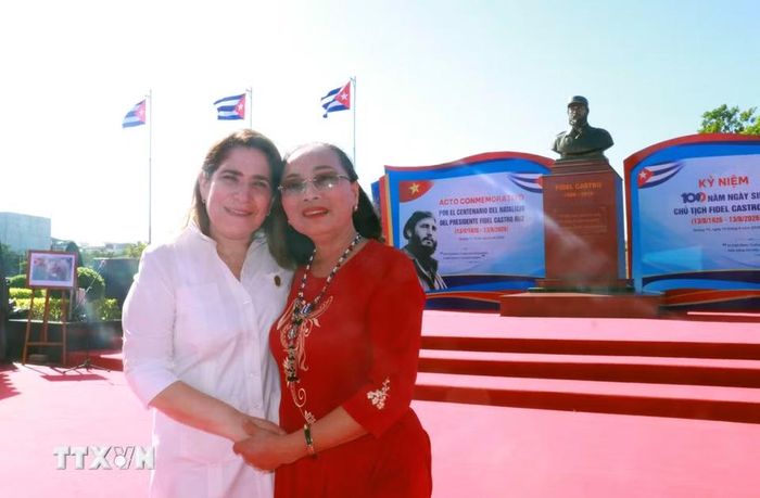 Bà Nguyễn Thị Hương, người được lãnh tụ vĩ đại Fidel Castro trực tiếp cứu sống sau khi bị thương nặng do bom mìn vào năm 1973, chụp ảnh lưu niệm với đại biểu của Đại sứ quán Cộng hòa Cuba tại công viên Fildel, tỉnh Quảng Trị. (Ảnh: Tường Vi/TTXVN)