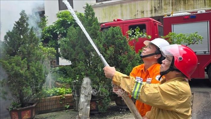 Công nhân ngành điện phối hợp với lực lượng phòng cháy, chữa cháy thực hành phun nước dập lửa trong tình huống giả định, góp phần nâng cao kỹ năng ứng phó và xử lý sự cố cháy, nổ tại đơn vị.