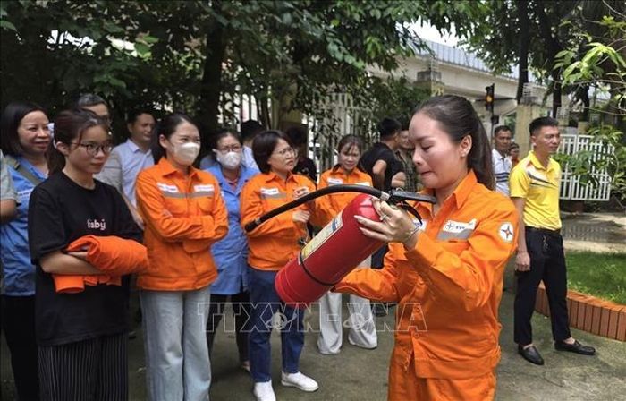 Cán bộ, công nhân ngành điện thực hành thao tác sử dụng bình chữa cháy xách tay dưới sự theo dõi của đồng nghiệp, qua đó nâng cao kỹ năng xử lý ban đầu khi xảy ra cháy, nổ.