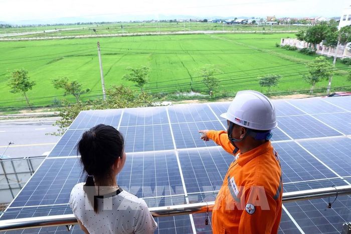Công nhân điện lực Can Lộc (PC Hà Tĩnh) hướng dẫn người dân cách sử dụng điện mặt trời áp mái hiệu quả. Ảnh: Huy Hùng - TTXVN 