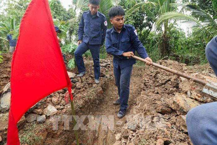 Khi phát hiện dấu vết nghi là nơi chôn cất liệt sĩ, lá cờ đỏ sẽ được cắm lên để đánh dấu. Ảnh: Hồng Thái - TTXVN