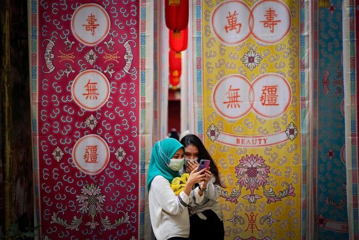 Hai cô gái đang xem điện thoại di động ở Kuala Lumpur, Malaysia. (Ảnh: AP)