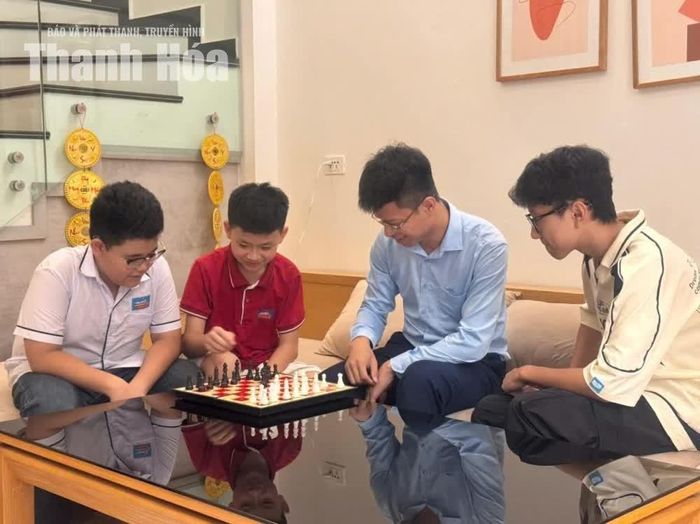 Mai Ngọc Duy (áo đỏ) chơi cờ cùng bố và các bạn.