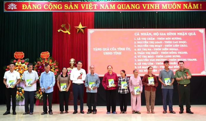 Các đồng chí lãnh đạo Công an tỉnh và xã Hợp Tiến trao quà cho gia đình chính sách, gia đình tiêu biểu tại ngày hội.
