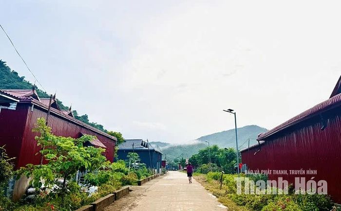 Con đường bê tông chạy dài giữa thôn, nối những nếp nhà dưới chân núi.
