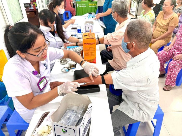 Trong quá trình khám sức khỏe định kỳ, khám sàng lọc miễn phí cho người dân, Trung tâm Y tế khu vực Sơn Trà tổ chức thu thập thông tin phục vụ khởi tạo sổ sức khỏe điện tử trên ứng dụng VNeID. Ảnh: ĐVCC