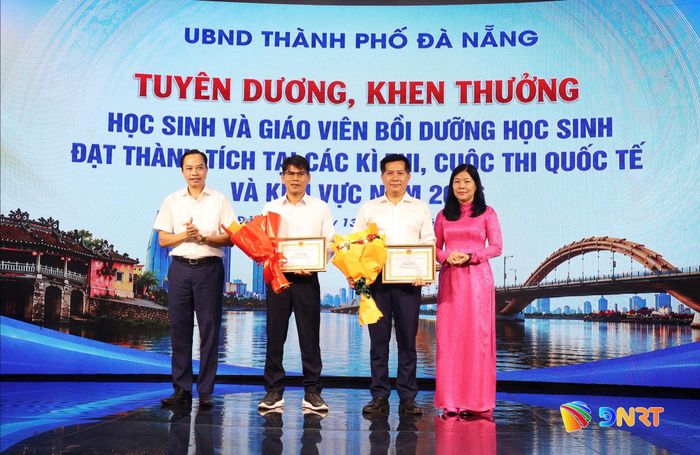 Trưởng ban Văn hóa - Xã hội HĐND thành phố Quảng Văn Ngọc (bìa trái) và Giám đốc Sở Giáo dục và Đào tạo Lê Thị Bích Thuận (bìa phải) khen thưởng giáo viên tham gia bồi dưỡng học sinh đạt thành tích cao. Ảnh: NGỌC HÀ
