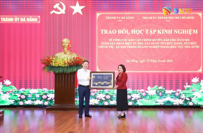 Trưởng ban Tuyên giáo và Dân vận Thành ủy Đà Nẵng Huỳnh Thị Thùy Dung (bên phải) tặng quà lưu niệm cho Ban Tuyên giáo và Dân vận Thành ủy Thành phố Hồ Chí Minh. Ảnh: NGỌC PHÚ