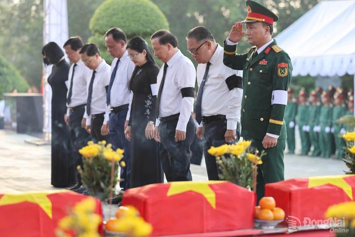 Lãnh đạo thành phố Đồng Nai dành phút mặc niệm, tưởng nhớ các liệt sĩ trước khi thực hiện nghi thức an táng liệt sĩ. Ảnh: CTV
