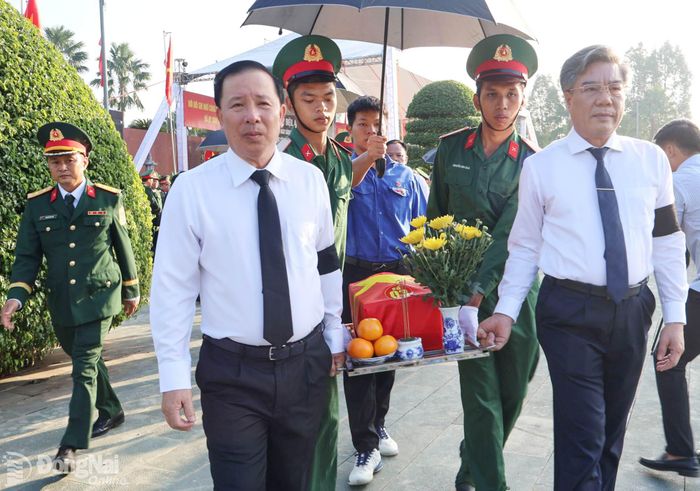 Phó Bí thư Thành ủy, Chủ tịch UBND thành phố Nguyễn Văn Út và Ủy viên Ban Thường vụ Thành ủy, Trưởng ban Tuyên giáo và Dân vận Thành ủy Dương Minh Dũng di quách hài cốt liệt sĩ về nơi an táng. Ảnh: Nguyệt Hà