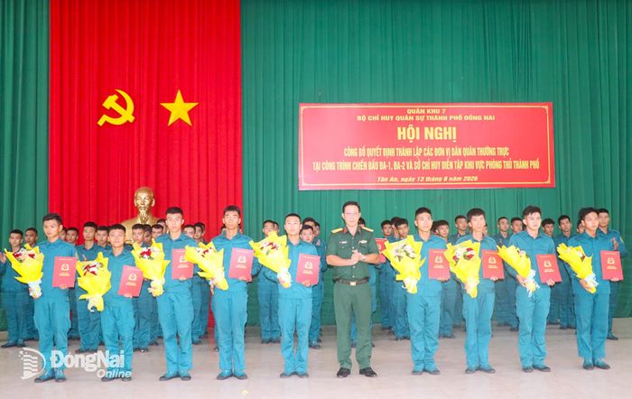 Thượng tá Trần Xuân Chiến, Phó Tham mưu trưởng Bộ Chỉ huy Quân sự thành phố Đồng Nai trao quyết định bổ nhiệm các Trung đội trưởng, Tiểu đội trưởng 3 đơn vị Dân quân thường trực bảo vệ các công trình chiến đấu. Ảnh: An Nhơn