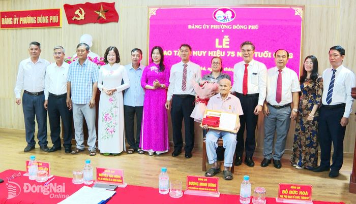 Ủy viên Ban Thường vụ Thành ủy, Trưởng ban Tuyên giáo và Dân vận Thành ủy Dương Minh Dũng cùng đại diện lãnh đạo Ban Tổ chức Thành ủy và Đảng ủy phường Đồng Phú chúc mừng đảng viên Phạm Đức Huân vinh dự được trao tặng Huy hiệu 75 năm tuổi Đảng. Ảnh: ĐVCC