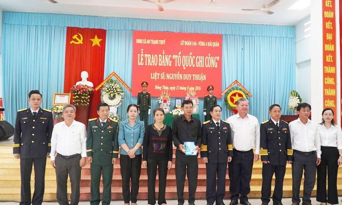 Đại diện lãnh đạo Vùng 4 Hải quân, Lữ đoàn 146, Sở Nội vụ và chính quyền địa phương chụp ảnh cùng thân nhân liệt sĩ.