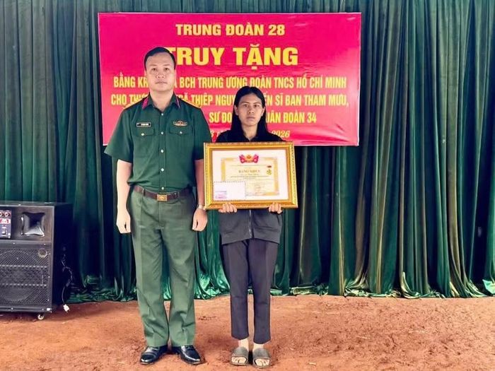 Đại diện Trung đoàn 28 trao bằng khen của Trung ương Đoàn cho đại diện gia đình Thượng sĩ Kpă Thiêp. Ảnh: N.T