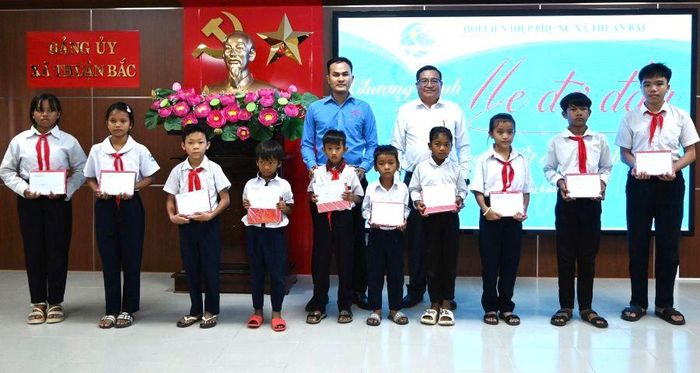 Lãnh đạo Đảng ủy xã Thuận Bắc và đại diện Công ty TNHH Xây dựng, Thương mại và Sản xuất Nam Thành Ninh Thuận trao quà cho các học sinh.