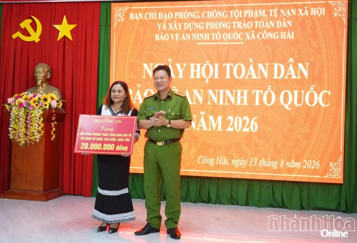 Đại tá Lê Quang Dũng trao phần thưởng của Bộ Công an cho mô hình “Mỗi hộ gia đình có thành viên tham gia phòng, chống tội phạm”.