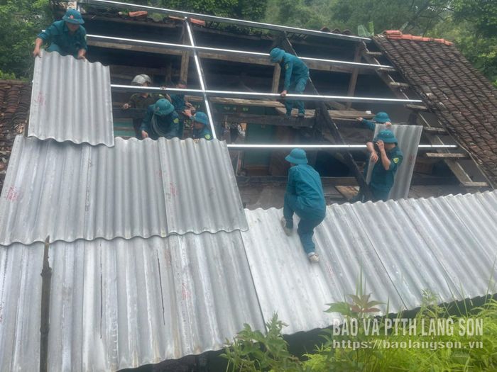 Lực lượng dân quân xã Điềm He tham gia hỗ trợ người dân lợp lại mái sau sự cố cháy nhà