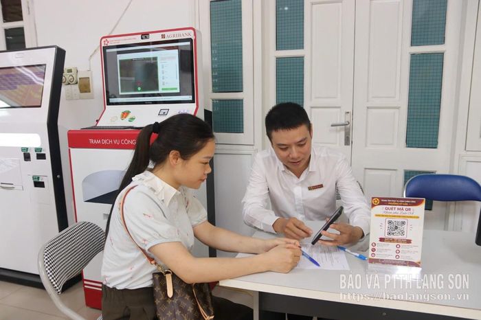 Cán bộ ngân hàng tư vấn cho người dân về các sản phẩm dịch vụ ngân hàng điện tử