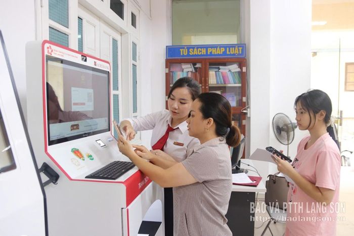 Cán bộ ngân hàng Agribank Chi nhánh Kỳ Lừa hướng dẫn người dân quét mã QR đăng nhập "Trạm dịch vụ công số" tại Trung tâm Phục vụ hành chính công phường Kỳ Lừa
