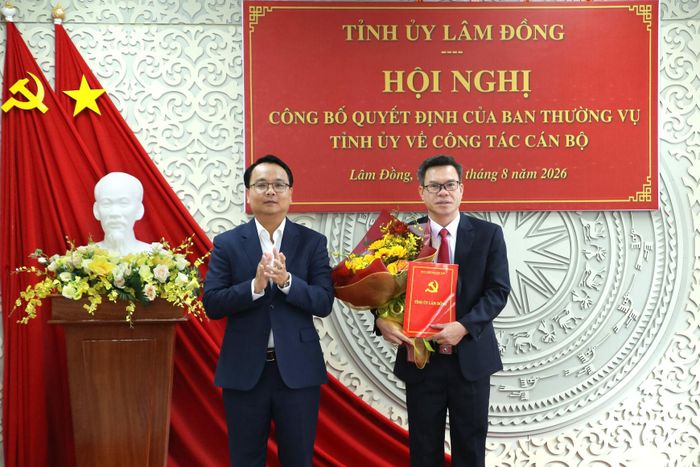 Đồng chí Đặng Hồng Sỹ, Phó Bí thư Thường trực Tỉnh ủy trao quyết định và tặng hoa chúc mừng đồng chí Nguyễn Văn Hữu