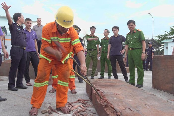 Lực lượng chức năng khoan, cắt các hộp gỗ để kiểm tra. Ảnh: Công an cung cấp