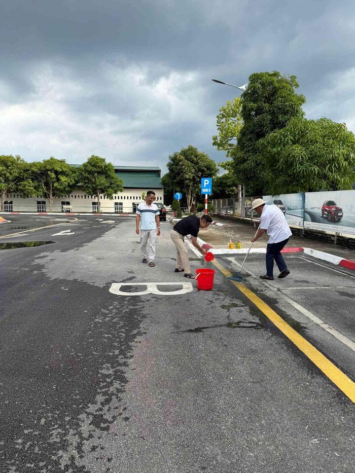 Cán bộ, nhân viên thực hiện vệ sinh, chỉnh trang khu vực sân bãi, góp phần duy trì môi trường đào tạo sạch, an toàn.