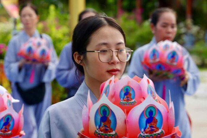 Phật tử thành kính dâng hoa sen tại khoá tu Pháp hội Dược Sư. Ảnh tư liệu