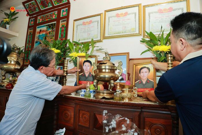Ông Phan Văn Tư trân trọng đặt di ảnh của 2 anh trai là liệt sĩ Phan Văn Ngọc và liệt sĩ Phan Văn Châu lên bàn thờ