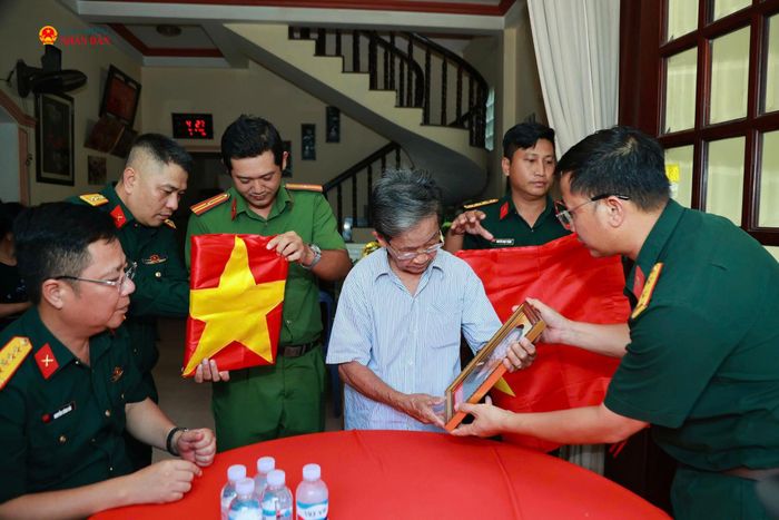 Ông Phan Văn Tư - con trai của Mẹ Việt Nam Anh hùng Huỳnh Thị Tui đón nhận di ảnh của 2 anh trai