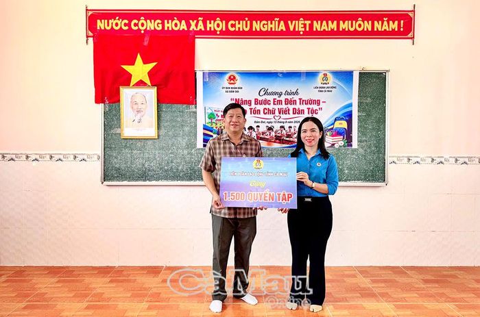 Bà Ngô Diễm Phúc, Phó Chủ tịch Thường trực Liên đoàn Lao động tỉnh Cà Mau, trao bảng tượng trưng tặng 1.500 quyển tập đến Chủ tịch UBND xã Đầm Dơi Nguyễn Trí Tài.