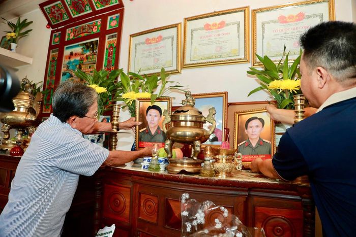 Hai bức di ảnh được trang trọng đặt lên bàn thờ