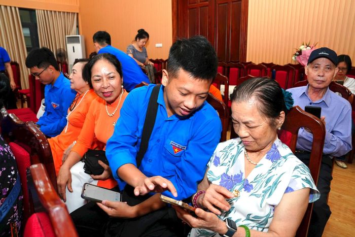 Đoàn viên thanh niên quận Tây Hồ (Hà Nội) hướng dẫn người cao tuổi truy cập và sử dụng các nền tảng ứng dụng công nghệ phổ biến. (Ảnh: Bộ KH&CN)