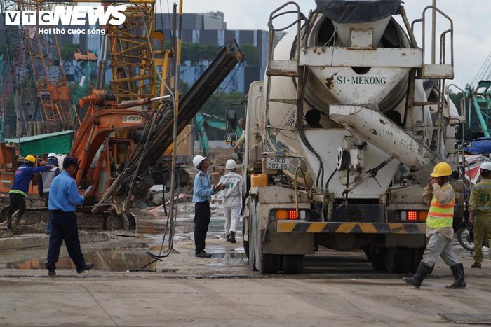 Nhiều phương tiện ra vào công trường, trong khi hệ thống máy móc phục vụ thi công nền móng vận hành không ngừng. Tiếng máy khoan, máy ép cọc và cần cẩu tạo nên không khí thi công khẩn trương tại khu vực dự án.